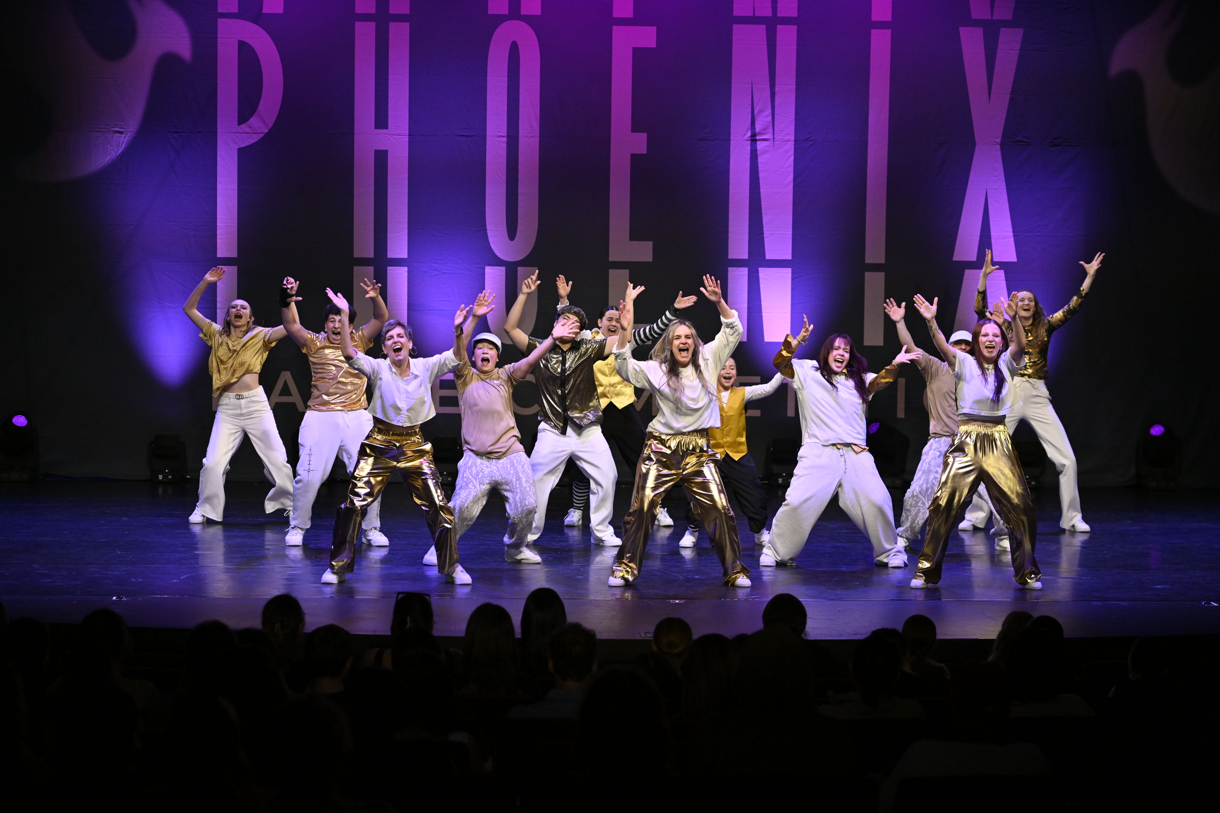 Pound It crew performing together on a purple-lit stage