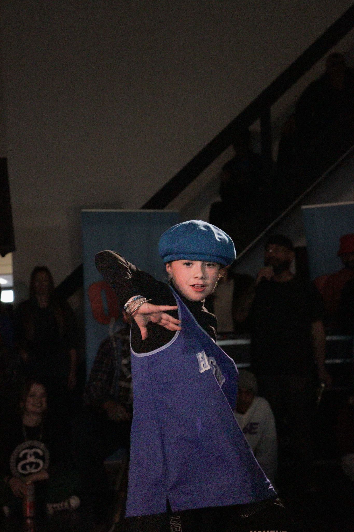Difficult C demonstrating a dance movement in a blue cap